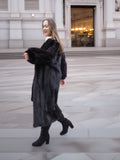 Woman in flowing dark ranch mink fur coat, highlighting the coat’s movement and luxurious natural fur quality.