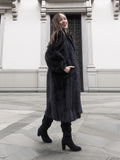 Model walking in classic black mink fur coat with voluminous sleeves and side pockets, ideal for luxury outerwear.