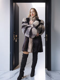 Woman wearing a fur coat and black boots standing in a doorway.