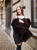 Off-shoulder styling of vintage mink coat, revealing inner lining and luxurious texture for upscale winter fashion.