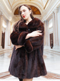 Model crossing arms in vintage mink coat, showcasing plush fur and timeless elegance in a marble hall.
