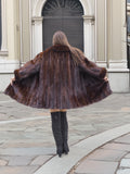 Back view of full-length mink coat spread wide, emphasizing its rich texture and luxurious fur craftsmanship.