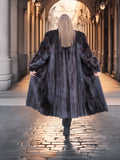 Back view of flowing Midnight Sonata black mink coat in motion, highlighting the coat’s dramatic volume and rich texture.