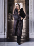 Woman wearing a long fur coat in an elegant interior setting