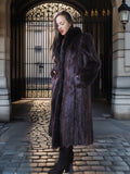 Woman in a fur coat standing in an elegant outdoor setting with architectural elements.