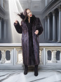 Woman wearing a long fur coat in an elegant interior setting