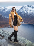 Red gray fox fur coat by The Wild Muse, modeled in a snowy fjord landscape, highlighting its plush texture and winter elegance.