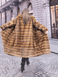 Back view of Harlow pastel mink coat in motion, showcasing its wide hem and luxurious horizontal mink stripes.