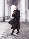 Model poses under archway in red and black mink fur coat, highlighting timeless elegance and fur craftsmanship.