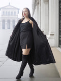 Model opens red and black mink fur coat to reveal black mini dress, blending vintage fur with modern fashion.