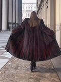 Back view of red and black mink fur coat flared open, showing dramatic chevron pattern and full-length design.