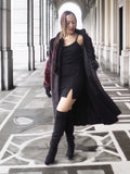 Model reveals inner lining of red and black mink fur coat over a black mini dress, highlighting versatile winter fashion.