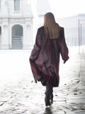 Back view of red and black mink fur coat in motion, emphasizing its full-length cut and dramatic winter style.