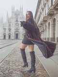 Model twirls in red and black mink fur coat near cathedral, combining classic architecture with elegant fur fashion.