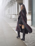 Side view of open red and black mink fur coat revealing black outfit underneath, perfect for chic winter layering.