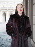 Close-up of model in red and black mink fur coat with fur collar and gloves, showcasing refined winter elegance.