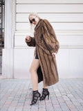 Elegant pastel brown mink fur coat with a silk lining, showcasing modern high-heel shoes against a white background.
