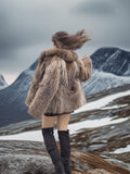 Back angle of Raccoon Glamour Jacket - Mountain Mirage S/M in snowy mountains, emphasizing natural fur flow and premium design.