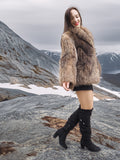 Model twirling in Raccoon Glamour Jacket - Mountain Mirage S/M on icy plateau, capturing playful elegance of fur fashion.