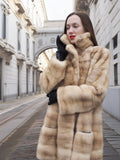 Blond pastel mink fur coat stroller jacket in modern design, styled with black gloves and red lipstick for elegant winter fashion.