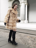 Smiling model walking in blond pastel mink fur coat stroller jacket, highlighting its comfort and chic winter appeal.