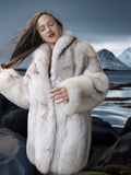 Woman wearing a fur coat with a snowy mountain landscape in the background