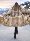 Back view of Finnish Raccoon Fur Coat in motion, showcasing expansive fur volume and dramatic silhouette on mountain road.