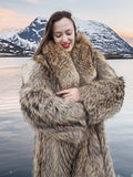 Model embracing plush Finnish Raccoon Fur Coat with thick collar, highlighting natural fur texture and warmth near icy lake.