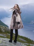 Silver fox fur coat with voluminous texture and luxurious design, worn overlooking a fjord. Real fur fashion jacket in M/L for cold weather.