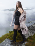 Elegant blue fox fur coat with voluminous shape and satin lining, worn on a misty mountain ledge. Premium outerwear for cold climates.
