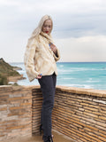 Reversible Versatile Sheared Mink Fur Jacket Coat S in beige mink fur, modeled with hand on collar near sea and ruins.