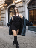 Model reveals black dress under The Still Hour deep teal fur coat, showcasing its luxurious lining and stylish winter appeal.