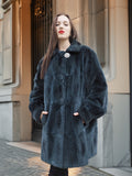 Close-up of The Still Hour sheared muskrat fur coat in deep teal, featuring a single button closure and soft, plush texture.