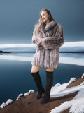 Woman in a fur coat standing on a snowy landscape with a body of water in the background