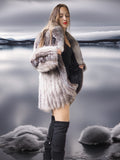 Woman wearing a fur coat and black boots standing in water with a scenic background
