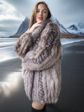 Woman wearing a fur coat with a snowy mountain landscape in the background