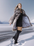 Woman in a fur coat standing on a snowy landscape with mountains in the background