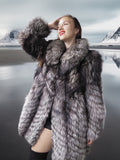 Woman wearing a fur coat with a mountainous landscape in the background