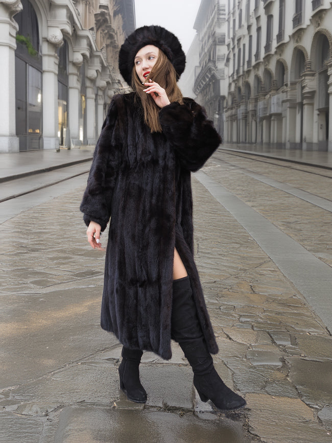 Dark Ranch Black Mink Fur Coat with matching mink hat, full-length design, worn with black boots on a cobblestone street. Elegant winter outerwear.