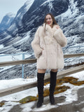 Soft Plush Blush Fox Jacket S/M styled with black boots, highlighting the coat’s warmth and elegance in a snowy outdoor setting.