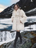 Soft Plush Blush Fox Jacket S/M styled on a snowy cliff, showcasing its voluminous fur and fashionable winter outerwear appeal.