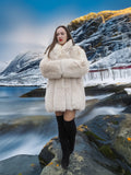 Model standing on rocks in Soft Plush Blush Fox Jacket S/M, highlighting the coat’s warmth and premium fox fur in a cold setting.