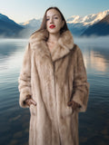 Woman in a fur coat standing in front of a mountain lake