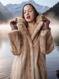 Woman wearing a fur coat with a mountainous landscape in the background
