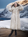 Model in Two Tone Fox Coat Size XS/S posing on a snowy deck, emphasizing the coat’s voluminous chevron fur and elegant winter style.