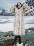Model in Two Tone Fox Coat Size XS/S standing on icy terrain, showcasing the coat’s plush texture and chevron design for cold-weather elegance.