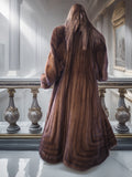 Brown fur coat displayed in a decorative interior setting with a mirror and ornate frame.