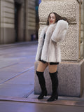 Model posing in Brown Cross Mink Fur Coat Jacket S with Blush Fox Trim against architectural backdrop, highlighting its soft fur and structure.