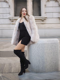 Model seated in Brown Cross Mink Fur Coat Jacket S with Blush Fox Trim, styled with a black mini dress for a sophisticated winter outfit.