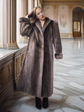 Woman wearing a long fur coat in an elegant interior setting